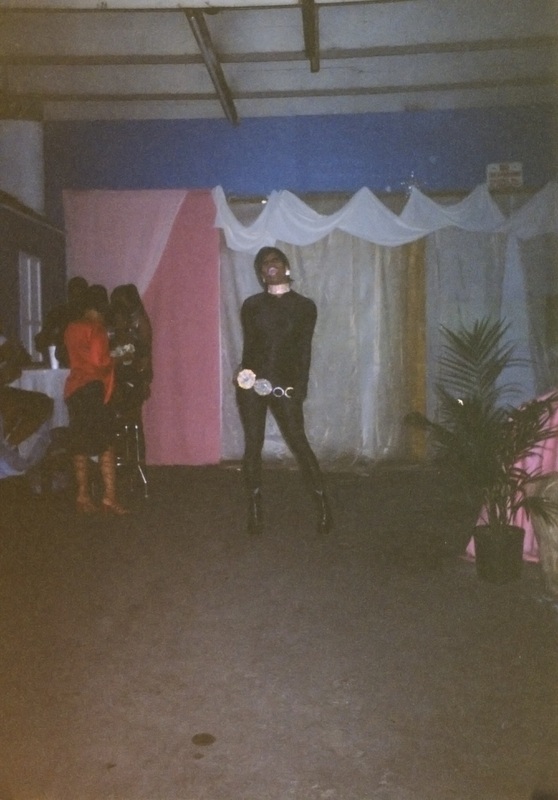 Feminine entertainer performs in Soakie's parking garage. 