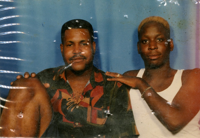 Three patrons stand in front of the bar at Soakie's. Two on the left happily embrace each other.