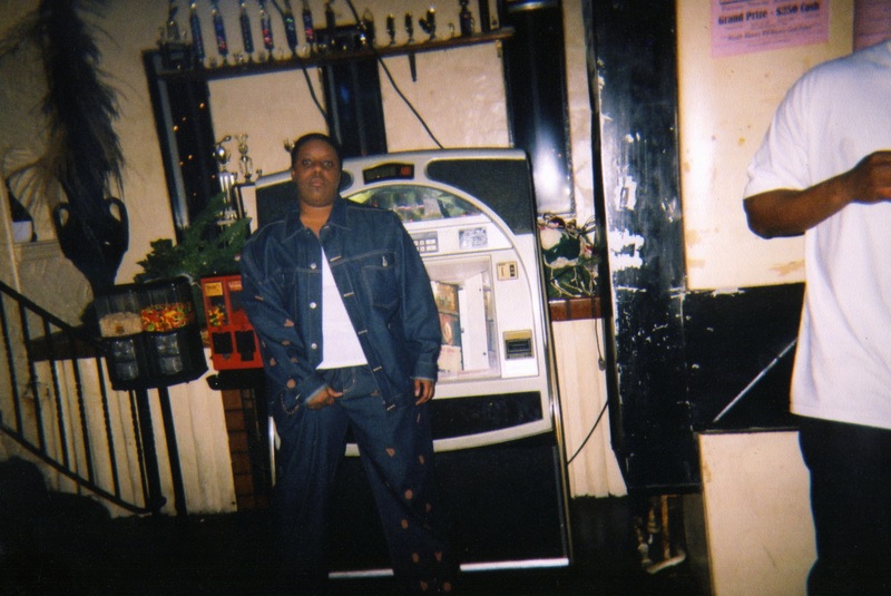 Starla Carr stands in front of Soakie's jukebox while dressed in her masculine drag persona.